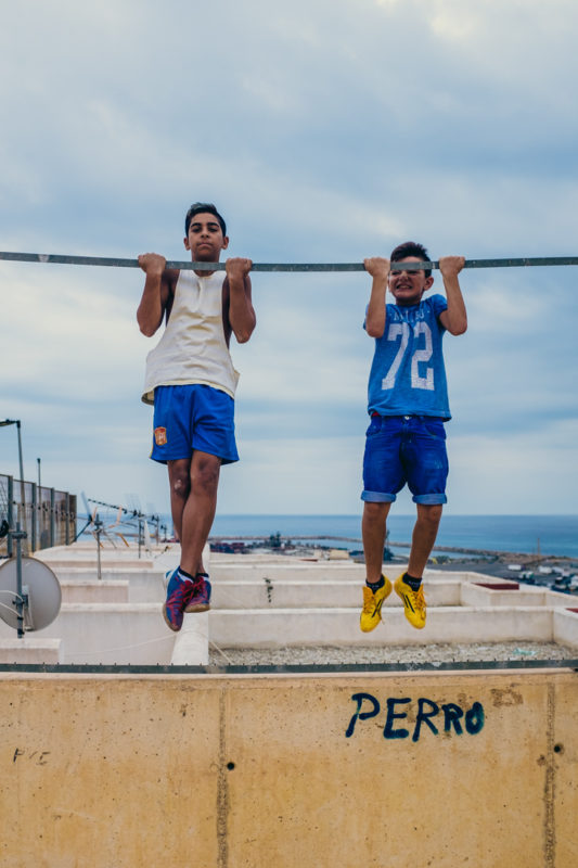 Niños haciendo flexiones en una barra