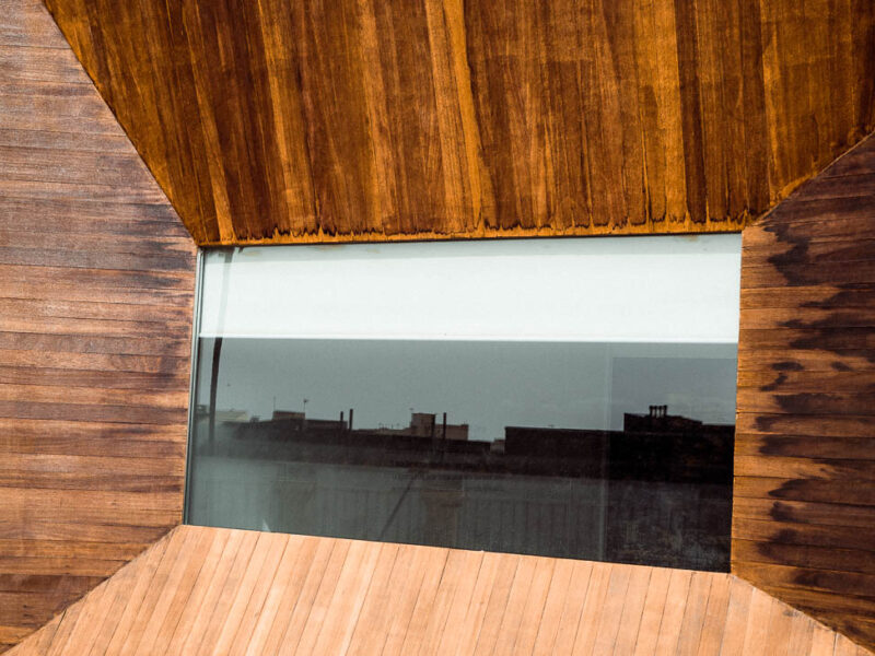 Una parte de la ciudad de Almería reflejada -monocromáticamente- en una ventana que la enmarca